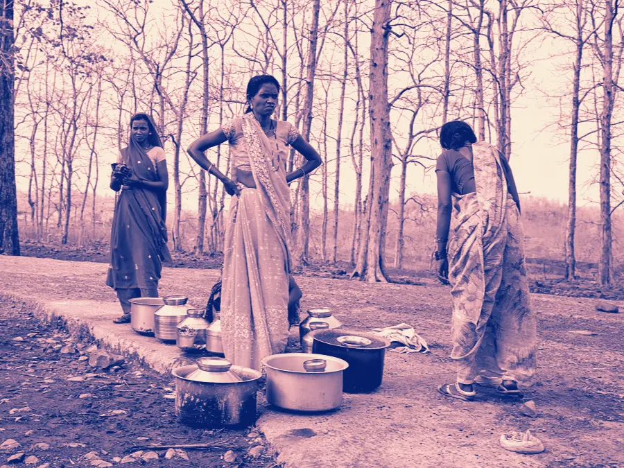 Women carrying water pots home from the village hand pump
